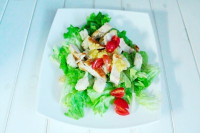 Caesar Salat mit Huhn Die Kirschtomaten anrichten und über die Sauce gießen. ?>